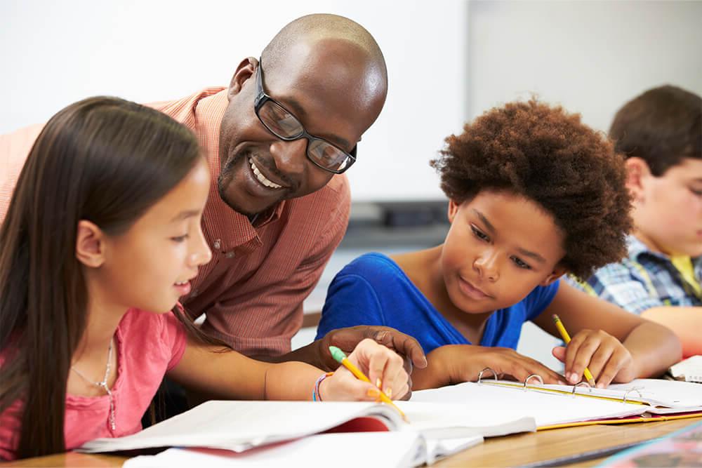 小学教育 teacher studying with young students